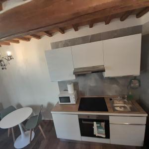 阿雷佐piccolo Garibaldi appartamento的厨房配有白色橱柜、水槽和桌子