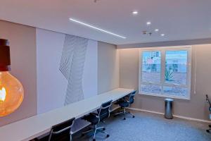 戈亚尼亚Blend Smart Marista 2 Quartos的办公室设有桌椅和窗户