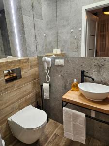 比亚韦斯托克Centrum Apartamenty 1000 Lecia 1 parking的浴室配有白色卫生间和盥洗盆。