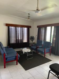 南迪Ziara Apartments的客厅配有蓝色的椅子和桌子