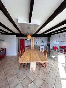BuissardLerefugedetiti的一个带木桌和椅子的大厨房
