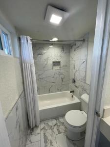安纳海姆Travel Inn Motel的白色的浴室设有卫生间和浴缸。
