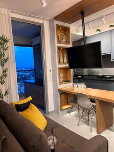里贝朗普雷托Fiusa Dream 153的客厅配有沙发和书桌及电视