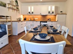 罗斯托克Familientraum auf 120 m2 in Rostock的厨房配有带白色椅子的木桌和用餐室。