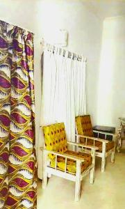 瓦塔穆Lalasalama B&B的一间设有两把椅子和窗帘的窗户的房间