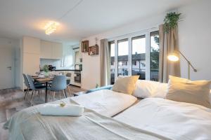 奥斯特蒙迪根Moderne Wohnung mit Parkplatz - Top Floor的一间带白色床的客厅和一间厨房
