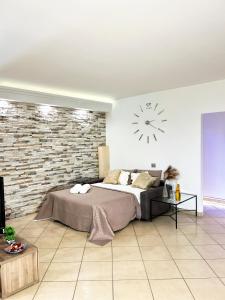 安格里Kiro Apartment Experience Pompei的卧室配有一张床,墙上挂着一个钟