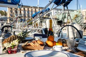 那不勒斯Barca a vela Kerama - Smart Wind的船上的餐桌,带食物和一瓶葡萄酒