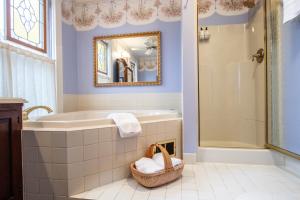 克里斯琴斯堡The Oaks Victorian Inn的带浴缸、水槽和镜子的浴室