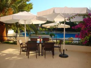 干尼亚瓦尔迪亚山酒店的庭院的白色遮阳伞下的桌椅