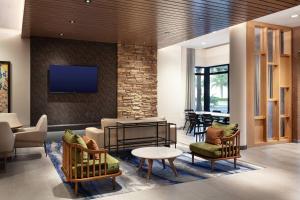 惠灵顿Fairfield Inn & Suites by Marriott Wellington-West Palm Beach的客厅配有椅子和墙上的电视