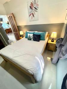 ValenciaDiez Dregger Fully Furnished Apartments的卧室配有带蓝色枕头的大型白色床