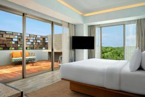 塞米亚克Aloft Bali Seminyak的一间带大床的卧室和一个阳台