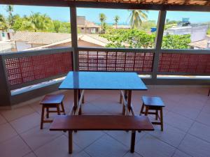 阿尔科巴萨Condomínio das gaivotas的阳台设有一张蓝色的桌子和两张凳子