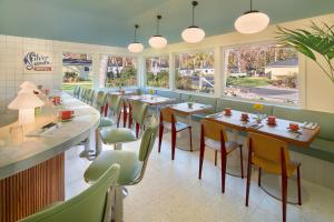 格林波特Silver Sands Motel & Beach Bungalows的用餐室设有桌椅和窗户。