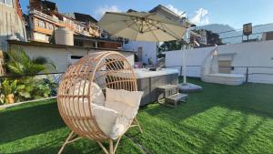 圣佩德罗拉拉古纳luxury atitlan suites的一把藤椅,坐在带雨伞的草坪上