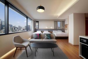 首尔Moxy Seoul Insadong的酒店客房,配有两张床和椅子