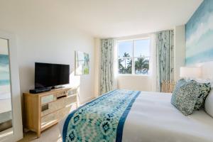 迈阿密海滩Marriott Vacation Club®, South Beach   的一间卧室设有一张床、一台电视和一个窗口。