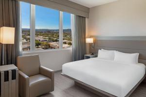 洛杉矶AC Hotel by Marriott Beverly Hills的配有一张床和一把椅子的酒店客房