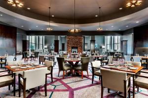 多伦多多伦多机场喜来登会议中心酒店的大型用餐室配有桌椅