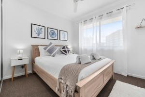 凯恩斯Spacious 3 Bedroom Townhouse in Cairns City的一间卧室设有一张大床和一个窗户。