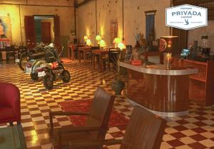 桔井PRIVADA LODGE的一间有摩托车停放在带桌子的房间的餐厅