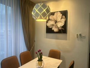 古晋Roxy Apartment Kuching的用餐室,配有一张桌子和花瓶