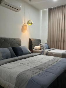 古晋Roxy Apartment Kuching的一间带两张床和一张沙发的卧室