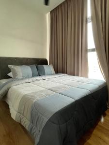 古晋Roxy Apartment Kuching的卧室内的一张大床,设有窗户