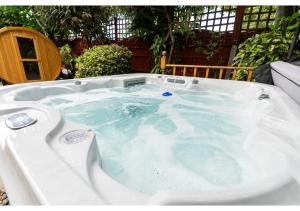 Canvey IslandNature's Serenade:3BR Classic Home-Jacuzzi & Sauna的庭院内装满水的按摩浴缸