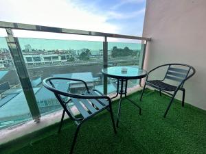 古晋Roxy Apartment Kuching的美景阳台配有一张桌子和两把椅子