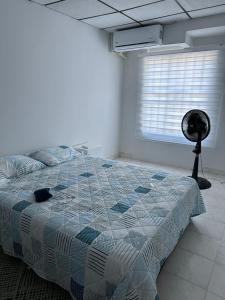卡塔赫纳Casa Tamarielys的一间卧室设有一张床、一个窗口和风扇