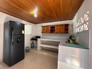 卡塔赫纳Casa Tamarielys的带冰箱和木制天花板的厨房