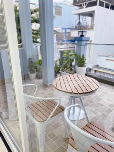 胡志明市SAIGONESE Studio的阳台配有一张桌子和两把椅子以及一张桌子