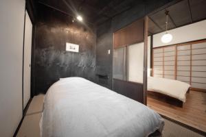 金泽YADOSU Arts and Stay的一间卧室配有一张床和一面镜子的墙壁