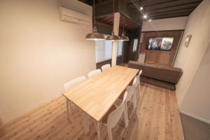金泽HISORI Arts and Stay的一间带木桌和白色椅子的用餐室