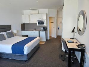 麦夸里港麦觉理港曼特拉码头酒店的一间带一张床和一张书桌的卧室和一间厨房