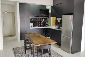 八打灵再也CANA Homestay Petaling Jaya的厨房配有木桌和冰箱。