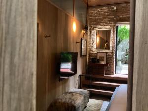 马六甲The Opposite Place的客房设有电视、搁脚凳和窗户。