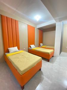 TinajeroXYC Hostel的橙色墙壁客房的两张床