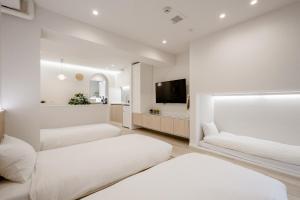 东京STAY ARI Shinjuku Gyoen 6Min walk的一间卧室配有两张床和一台平面电视