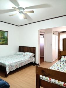 San JuanChavenogue Hotel的一间卧室配有两张床和吊扇