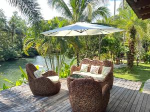 象岛Nanai Resort Salakphet的庭院配有两把椅子和一把遮阳伞