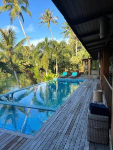 象岛Nanai Resort Salakphet的棕榈树甲板上的游泳池