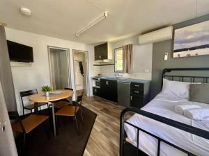 扬Young Caravan and Tourist Park的一间卧室配有一张床铺和一张桌子,还设有一间厨房