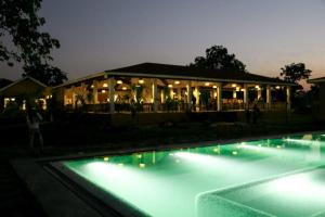 KotaAnaya Resort的游泳池旁的一座建筑,晚上有灯