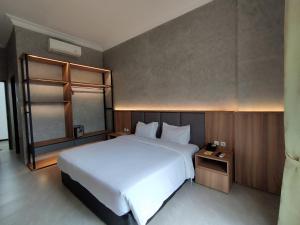 玛琅马朗大皇宫酒店的卧室配有一张白色的大床和一张桌子