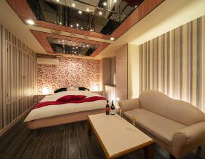京都百花园酒店（仅限成人）的一间卧室配有一张床和一张沙发