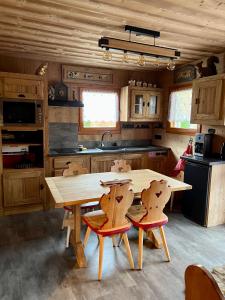 Saint-Laurent-en-Grandvauxl'écureuil的厨房配有木桌和两把椅子