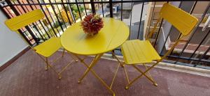 卡斯特罗维拉里Pollino guest house的一张黄色桌子和两把椅子,上面有 ⁇ 萝